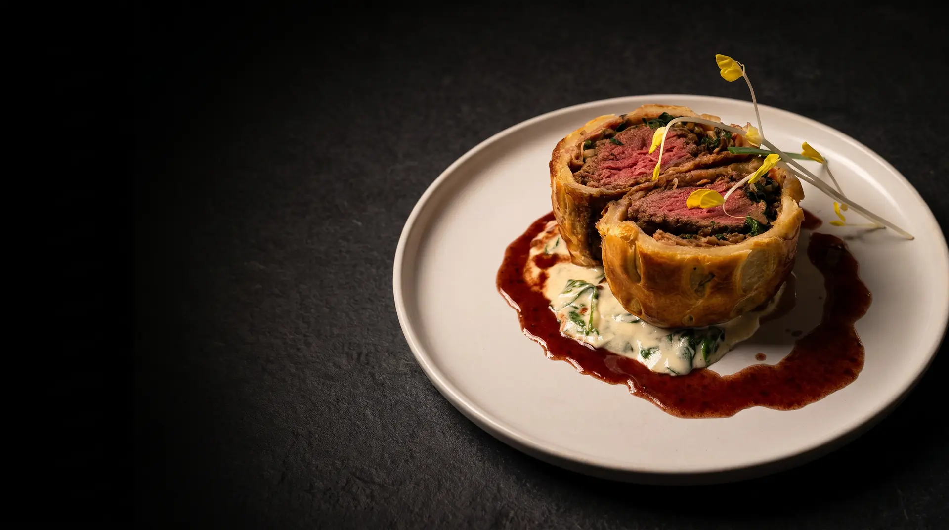Beef Wellington relleno de setas, espinaca y jamón serrano sobre crema de espinaca